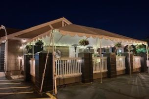 A tranquil cemetery with floral arrangements under a canopy of trees during daytime.